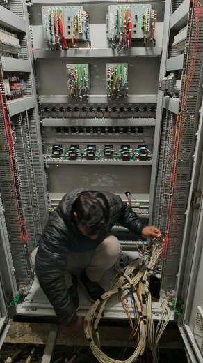 Engineer carrying out wiring work inside a control panel