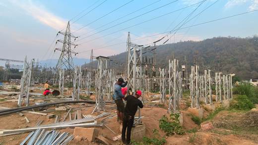 Workers erecting a galvanized steel support structure at the substation site