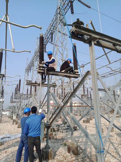 Team installing equipment on a switchyard support structure